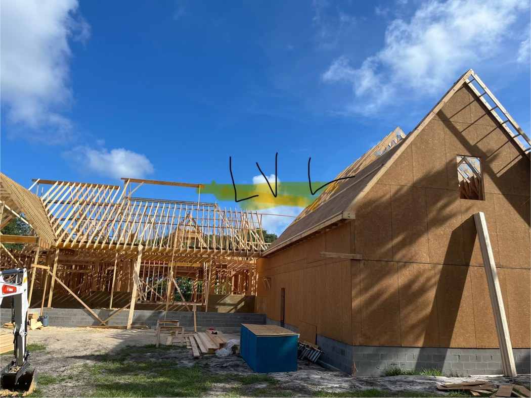 Roof truss framing against a blue sky